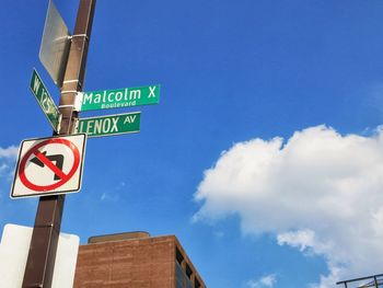 Low angle view of road sign against blue sky
