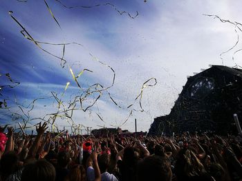 Crowd at music concert against sky