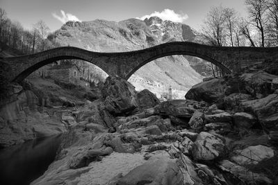 Arch bridge over river against sky