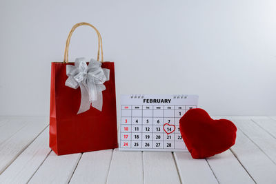 High angle view of calendar by gift box and heart shapes on table