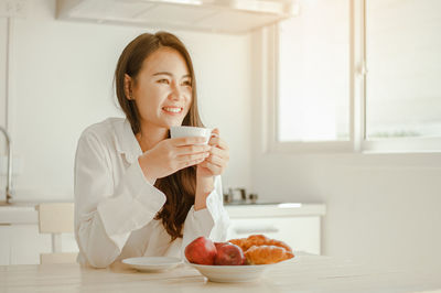 Portrait of young woman drinking coffee cup