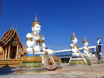 Statue against temple building against clear sky