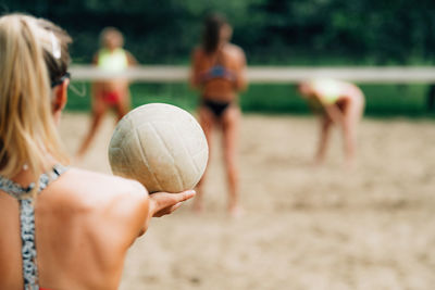 Beach volleyball, female player serving the ball