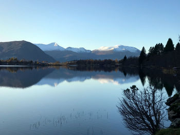 Scenic view of lake and mountains against clear sky