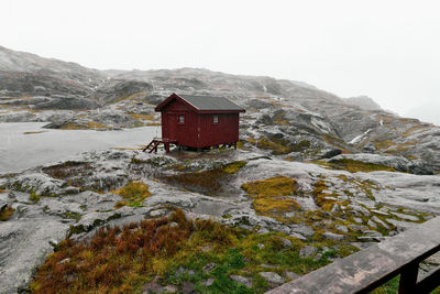 Remote isolated munkebu cabin with rocky wet landscape on rainy day in winter lofoten islands