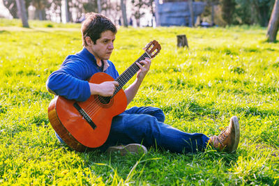 Man playing guitar on field