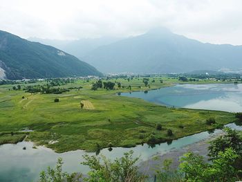 Scenic view of field and mountains against sky