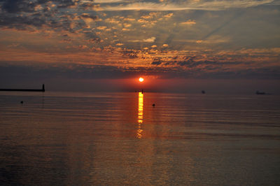 View of seascape against cloudy sky at dusk