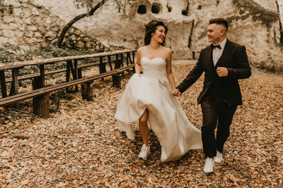 Low section of bride and groom standing on field