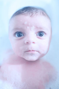 Close-up high angle view of cute baby boy taking bubble bath