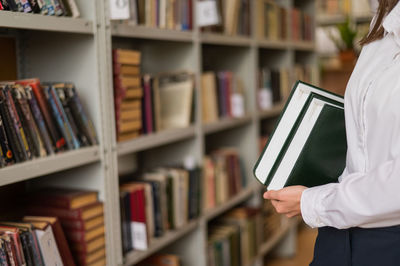 Midsection of woman standing in library