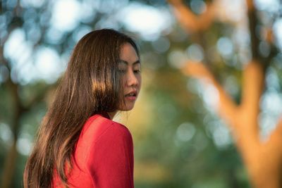 Side view of young woman at park