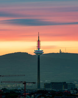 Tower and buildings against sky during sunset