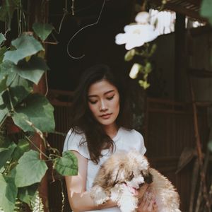 Young woman with dog by plants