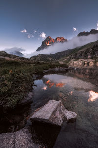 Scenic view of lake by mountains against sky