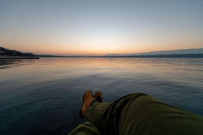 Guy chilling at the water's edge in the lac léman geneva