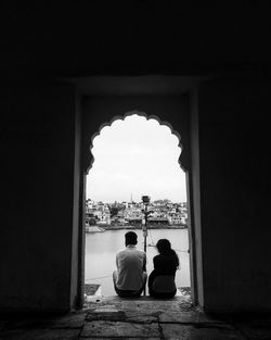 Rear view of men sitting in front of man