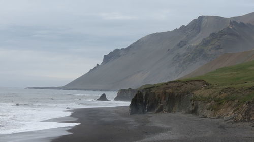 Scenic view of sea and mountains against sky