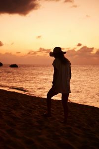 Full length of silhouette man standing on beach against sky during sunset