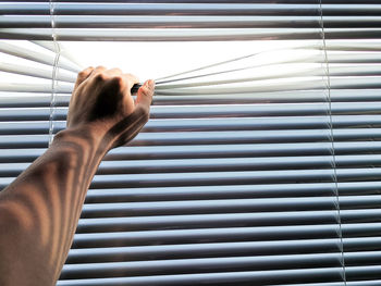 Close-up of human hand on metal window