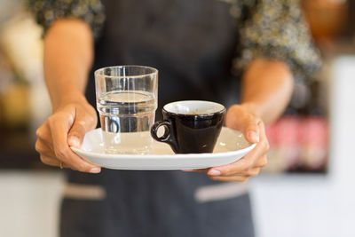 Midsection of woman with coffee cup