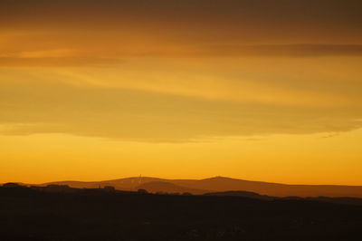 Scenic view of silhouette mountains against romantic sky at sunset