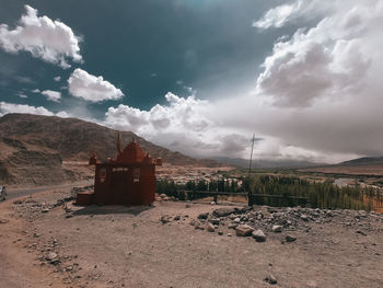 Scenic view of land and buildings against sky