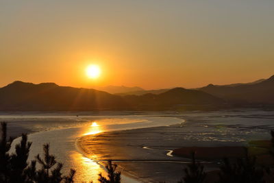 Sun shining through clouds over mountains
