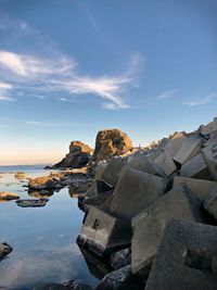 Rock formations by sea against sky