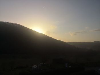 Scenic view of silhouette mountains against sky during sunset