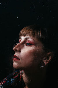 Close-up portrait of man against black background