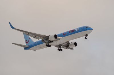 Low angle view of airplane flying against sky