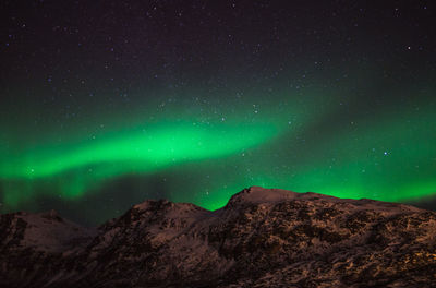 Scenic view of mountain against aurora borealis at night