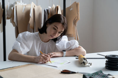 Woman looking at camera while sitting on table