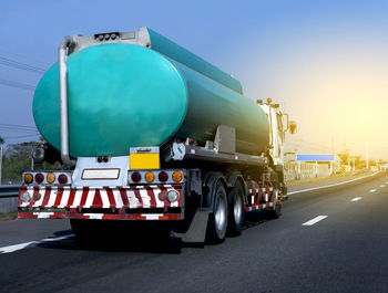 Commercial land vehicle on road during sunset