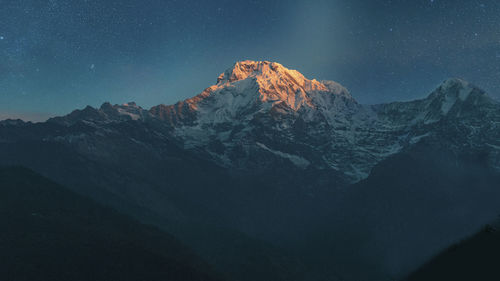 Scenic view of machapuchare snowcapped mountains against sky at sunrise