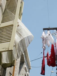 Low angle view of clothes drying against clear sky