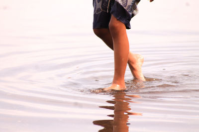 Low section of woman standing in sea