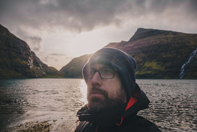 Portrait of young man at beach against sky