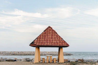 Lifeguard hut on beach against sky