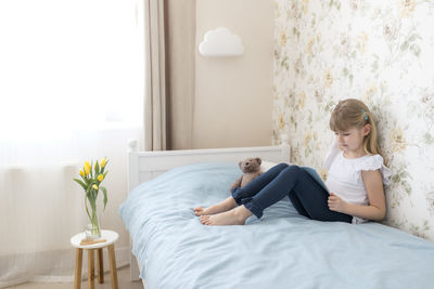 Woman sitting on bed at home