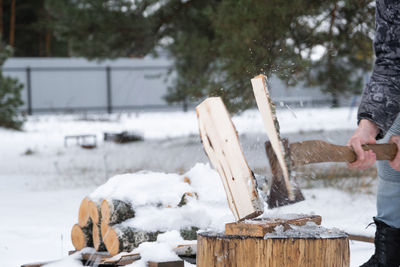 Cropped hand of man working on snow