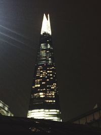 Low angle view of illuminated buildings against sky at night