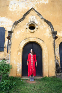 Full length of woman standing by building