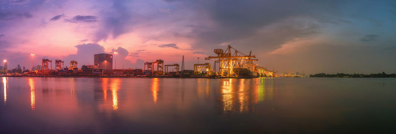 Panoramic view of illuminated city against sky at sunset