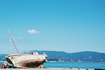 Boats moored on sea against blue sky
