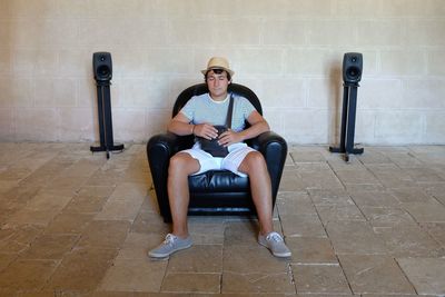 Young man with eyes closed sitting on armchair