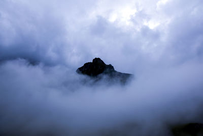 Silhouette mountain covered with clouds