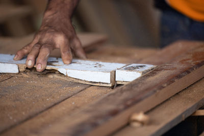 Carpenter, senior man sanding wooden fence in workplace using work tool