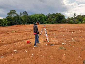 Full length of man surveying on field